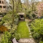 Lush backyard garden with vibrant trees, shrubs, and a well-maintained lawn.