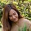 Young woman gardening in a lush green outdoor setting.